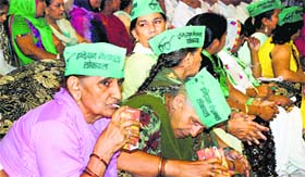 Donning INLD caps, women drink juice during a rally of the party at Sector 16 in Panchkula on Sunday.