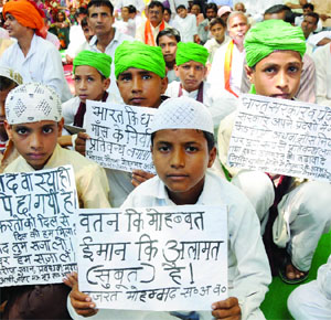 Children hold placards as they participate in the 'Sarva Dharma Sansad' to preach brotherhood among all religions on International Peace Day at Jantar Mantar in New Delhi on Sunday.