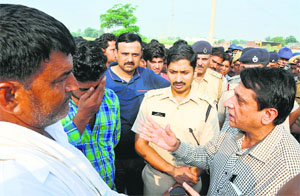 Deputy Commissioner Balraj Singh (right) and SP Abhishek Garg (second from right) pacify Narinder Kumar's kin who were with him when the incident occurred on Sunday morning. 