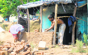 Balbir Chand and his wife Asha Devi rebuild their house at Lalyal village of Jammu on Sunday. 