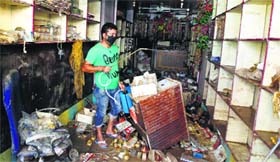 A Kashmiri man sprays disinfectant in a shop which was damaged by flooding in Srinagar.