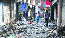 Employees of the Srinagar Municipal Corporation clean waste from the flood-hit Lal Chowk area in Srinagar on Sunday.