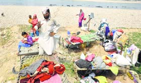 A flood-affected Gujjar family living in the open after their house was damaged.