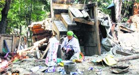 A flood victim salvages her belongings from her collapsed house in Pulwama on Sunday.