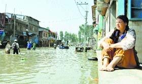A German married to a Kashmiri man sits in her partially submerged house on the outskirts of Srinagar on Saturday.