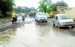 Commuters pass through the potholed Sherpur Road in Jagraon