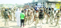 Policemen convince protesters to clear the road at Badli town in Jhajjar. Photo: Sumit Tharan