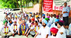 Employees of the Punjab Water Supply and Sewerage Board protest outside the office of the Ludhiana Improvement Trust in Ludhiana.