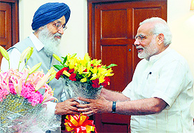 Chief Minister PS Badal presents a bouquet to PM Narendra Modi in New Delhi on Monday.