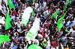 Mourners carry the bodies of Marwan Kawasme and Amar Abu Aysha (inset) during their funeral in the West Bank city of Hebron on Tuesday