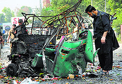 A security official looks at the wreckage of a rickshaw after it was damaged during an attack on a Frontier Constabulary convoy in Peshawar on Tuesday
