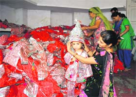 A langoor selects a dress from a pile of dresses at Bara Hanuman Mandir, Durgiana Temple, in Amritsar on Wednesday