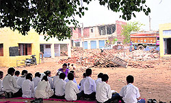 Students attend class in the open in Sure Chak village of Jammu on Wednesday
