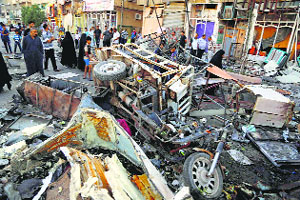 Iraqis gather at the car bomb site in Sadr City, Baghdad, on Wednesday. Fourteen persons were killed in the car bomb explosion.