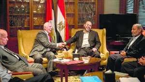 Palestinian negotiator Azzam al-Ahmad (2nd from left) of the Fatah movement shakes hands with Hamas deputy leader Musa Abu Marzouk (2nd from right) in Cairo on Wednesday.