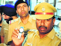 A police official shows a seized branded duplicate watch during a raid in the Industrial Area, Phase I, Chandigarh, on Thursday. Tribune Photo: Pradeep Tewari