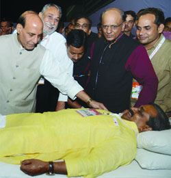 BJP Delhi president Satish Upadhyay donating blood while the senior party leader Rajnath Singh blesses him on the occasion of the birth anniversary of Pt. Deen Dayal Upadhyay in New Delhi on Thursday