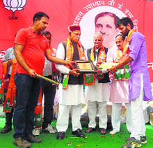 Former Chief Minister PK Dhumal honours party members at Baroha in Hamirpur on Thursday.