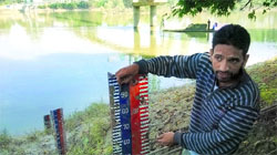 A junior-level flood gauge reader at Ashim in north Kashmir shows the level of water which the Jhelum had reached on September 7 when Srinagar was flooded. A Tribune photograph
