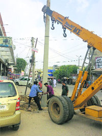 An electricity pole being removed from the middle of a road in Ludhiana. 