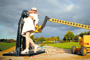Workers prepare the Unconditional Surrender sculpture by artist Seward Johnson of the US outside the Memorial of Caen museum in Caen on Thursday. The 25-foot statue of a sailor kissing a nurse is to spend a year in front of the Caen Memorial.