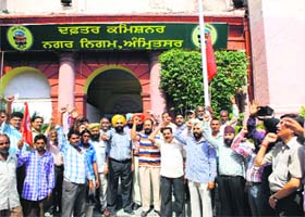 MC employees observe a strike and raise slogans against the Municipal Corporation authorities, which have failed to pay their salaries in Amritsar on Friday