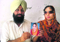 Acid attack victim Amanpreet Kaur with her father holding her old photo. a File Photograph