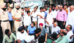Shopkeers of the Kikkar Bazar protest in front of the MC staff in Bathinda on Friday. Tribune photo
