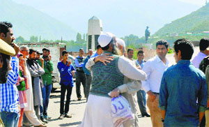 Flood-affected Pakistan-occupied Kashmir residents hug their relatives before boarding the Karwan-e-Aman bus to return home at the Salamabad Trade Centre in Uri, north Kashmir, on Friday