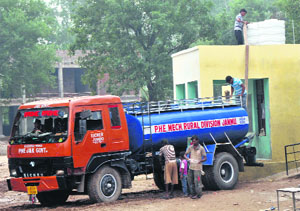 A tanker of the PHE Department supplies drinking water to residents at flood-affected Phalian Mandal village in Jammu. 