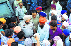Police officials try to pacify residents of Machian Kalan village in Ludhiana on Friday. Tribune photograph