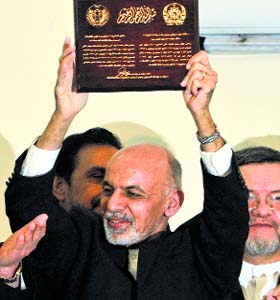 Afghan president-elect Ashraf Ghani holds up a certificate presented to him in Kabul