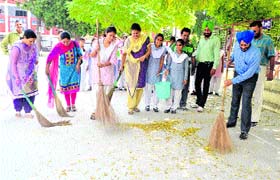 District Education Officer (Secondary) Satinderbir Singh cleans school premises along with students during the launch of Swachh Bharat Abhiyaan at Government Girls Secondary School, the Mall, in Amritsar on Saturday
