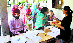 Bank officials help slum dwellers fill in documents at Leisure Valley in Ludhiana