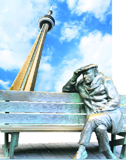 A view of the CN Tower from below and Man on the Bench, one of the most photographed sculptures
