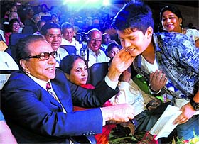 Bollywood actor Dharmendra congratulates one of the contestants after his performance during a cultural evening, Sur Sangam-2014, at Tagore Theatre in Chandigarh on Sunday