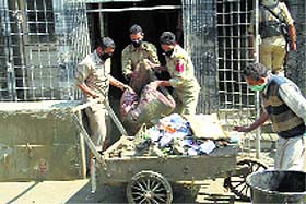 policemen clean the premises of a hospital in Srinagar.
