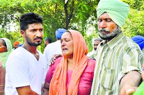 Residents console the grieving mother of the deceased brothers, Gurmeet Kaur, during a dharna at Neelon on Sunday