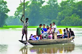 Villagers move to a safer location on a boat at Jamunamukh area of Nagaon in Assam following floods on Sunday