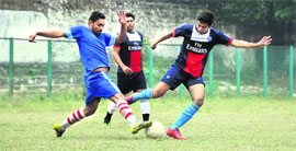 players vie for the ball during a match in the District Football League at Pavillion Ground in Dehradun on Sunday