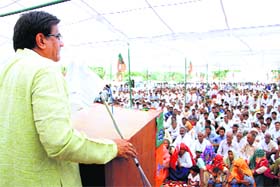 BJP Kisan Morcha president and the partys nominee from Badli Om Prakash Dhankar addresses a public meeting at Sikanderpur village in Jhajjar on Monday