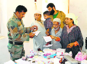 Flood victims at a free medical camp organised by the Army at Litter village in Pulwama district of south Kashmir on Monday. 