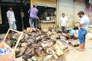 Shopkeepers in Srinagar taking out the damaged stuff from their shop.