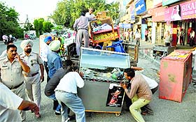 MC staff confiscate rehris and other material at the Sarabha Nagar market in Ludhiana on Monday.