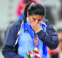 Seema Punia wipes her tears after receiving gold medal.