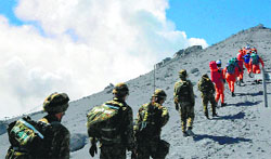 Japans Self Defense Force soldiers and rescue workers search for survivors and missing climbers on the ash covered top of Mount Ontake at Nagano prefecture on Monday. AFP