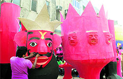 An artisan gives a finishing touch to an effigy of Ravana