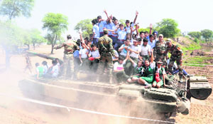 Schoolchildren sit atop a battle tank and take a ride without any safety measures in the K-Area during the “Know Your Armed Forces” event organised by the Western Command Headquarters at Zirakpur on Tuesday.