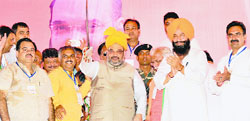 BJP chief Amit Shah (second from right) with Assandh candidate Bakshish Singh Virk (extreme right) during a rally at Taraori in Karnal district on Tuesday. Tribune photo: Ravi Kumar