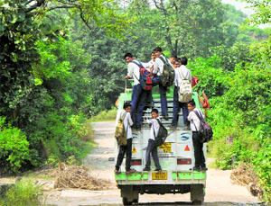Schoolchildren sit on the roof of a minibus at Bajalta village in Jammu.